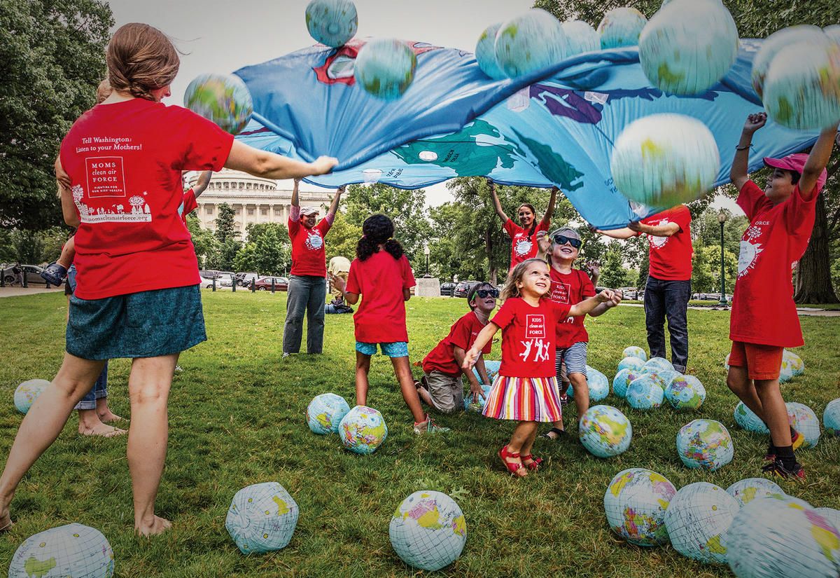 Moms playing with kids in Kids Clean Air Force t-shirts in front of the U.S. Capitol Building