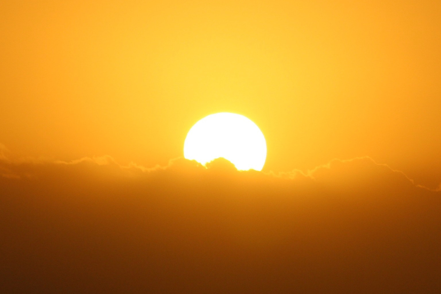 Sun setting behind clouds