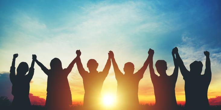 People with joined, raised hands